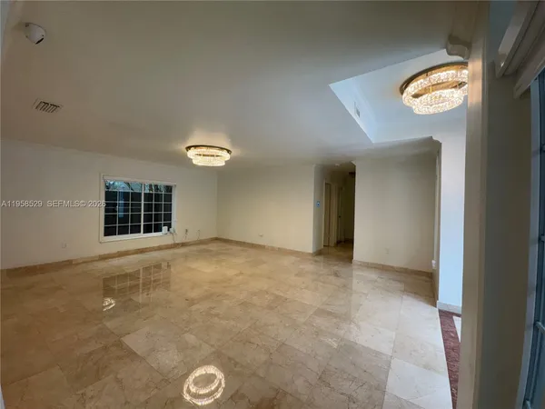 an empty room with a chandeliers fan