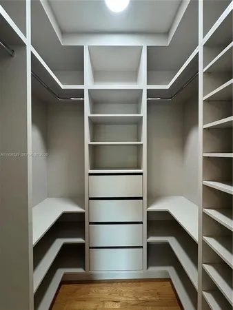 a view of walk in closet with empty racks
