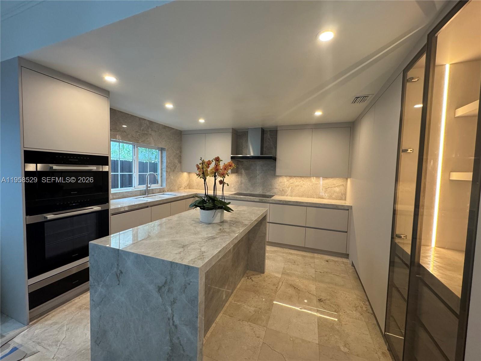 3185 Washington Street Miami, FL 33133 - Photo 5 of 48 a kitchen with stainless steel appliances granite countertop a sink stove and refrigerator