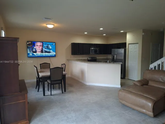 a view of kitchen with kitchen island dining table and chairs