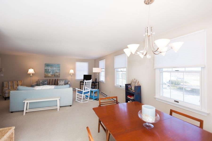 99 Depot Road, Unit 24 Chatham, MA 02633 - Photo 3 of 17 a living room with furniture a chandelier and a large window