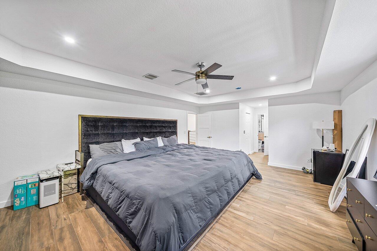 10223 Boca Vista Drive Boca Raton, FL 33498 - Photo 17 of 33 a bedroom with a bed and wooden floor