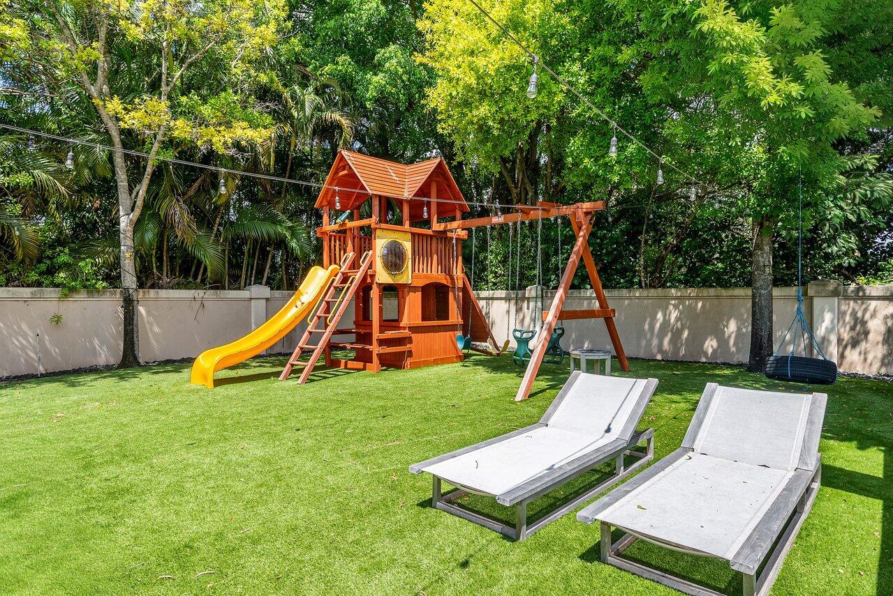 10223 Boca Vista Drive Boca Raton, FL 33498 - Photo 27 of 33 a view of playground with a slide and swing