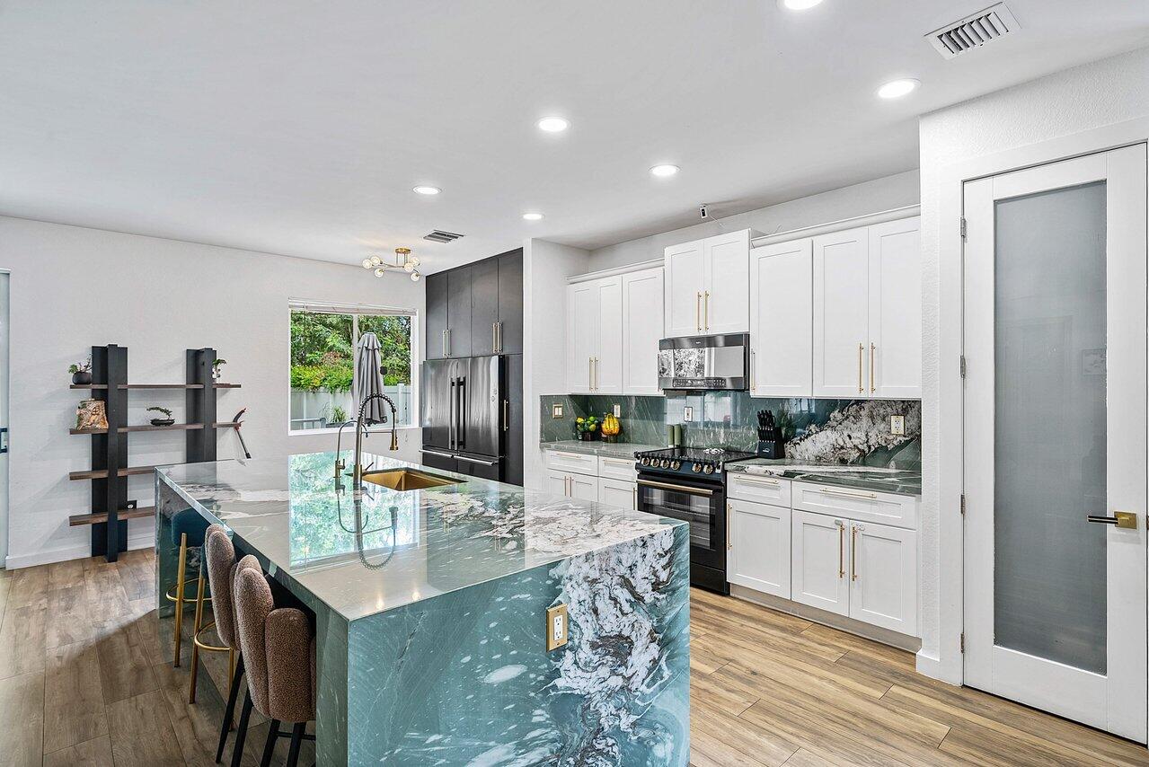 10223 Boca Vista Drive Boca Raton, FL 33498 - Photo 7 of 33 a kitchen with stainless steel appliances granite countertop a sink stove and refrigerator