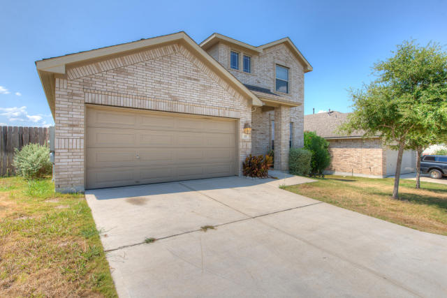 321 Limestone Trail Austin, TX 78737 - Photo 2 of 28 a front view of a house with a yard and garage