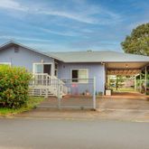 a front view of a house with a yard and potted plants