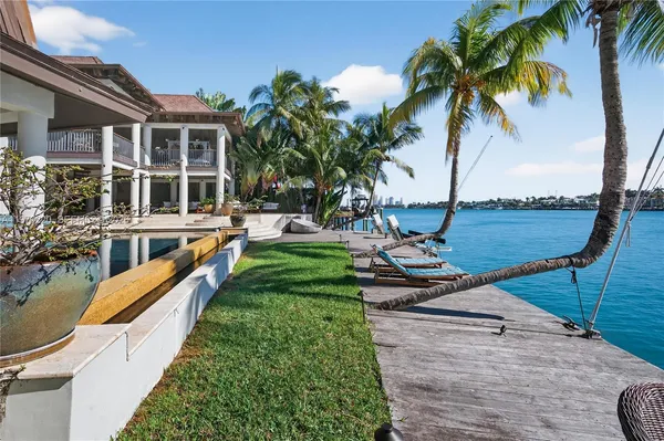 a view of a livingroom with furniture staircase and a floor to ceiling window