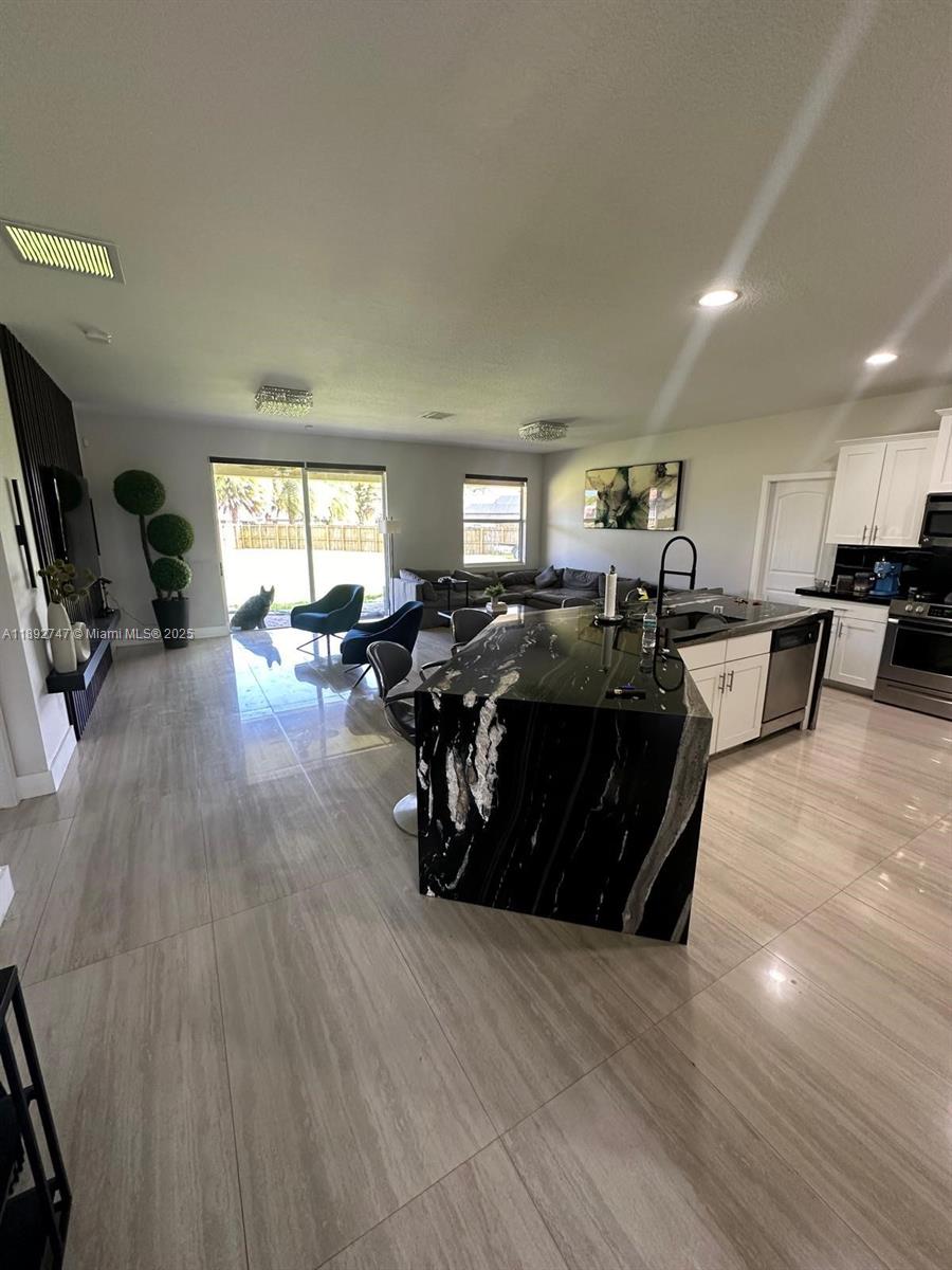 12944 Southwest 222nd Street Miami, FL 33170 - Photo 5 of 7 a living room with lots of furniture and a wooden floor
