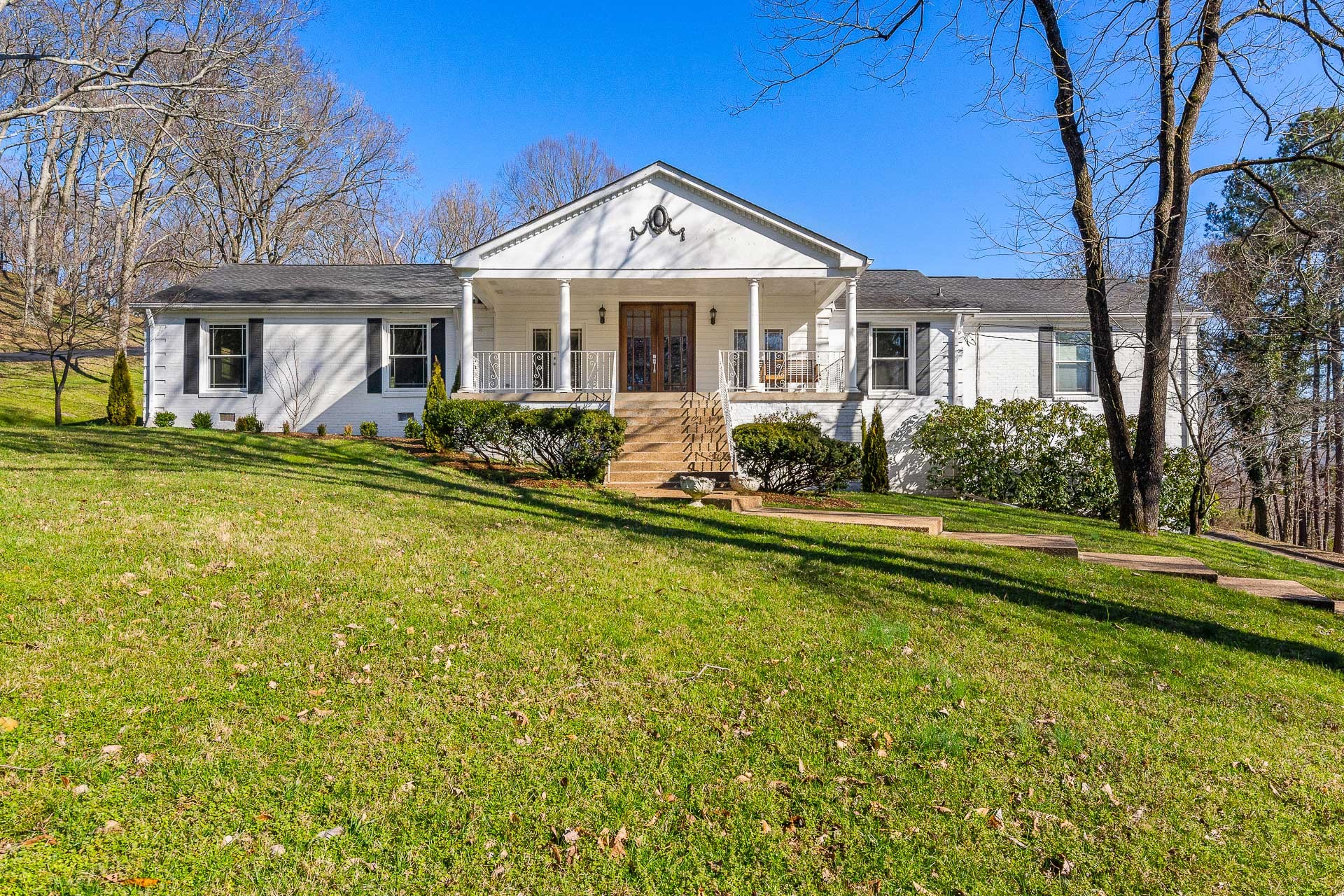 6607 Fox Hollow Road Nashville, TN 37205 - Photo 1 of 50 a front view of a house with a yard table and chairs