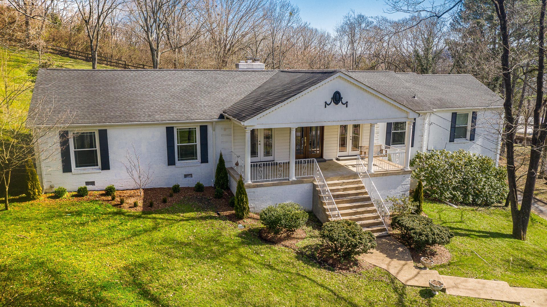 6607 Fox Hollow Road Nashville, TN 37205 - Photo 3 of 50 a front view of a house with a yard table and chairs