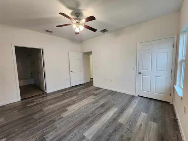 a view of empty room with wooden floor