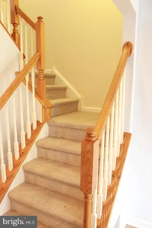 a view of staircase with railing and white walls