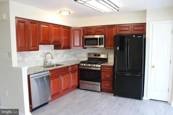 a kitchen with stainless steel appliances granite countertop a refrigerator stove and sink