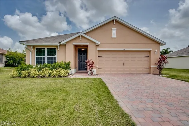 a front view of a house with a yard and garage