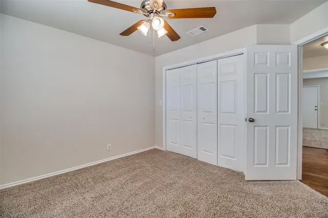 an empty room with closet and fan