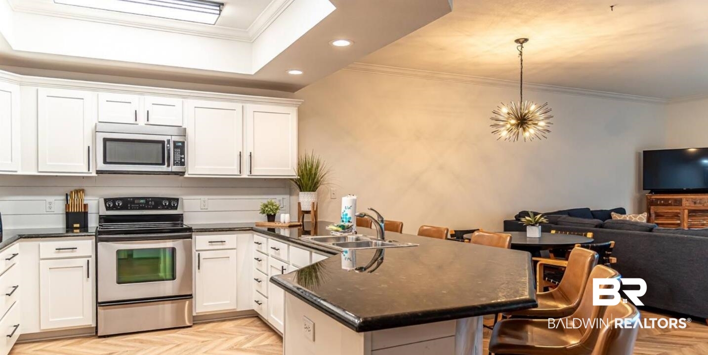 27800 Canal Road, Unit 212 Orange Beach, AL 36561 - Photo 43 of 43 Kitchen featuring a peninsula, ornamental molding, appliances with stainless steel finishes, a sink, and open floor plan