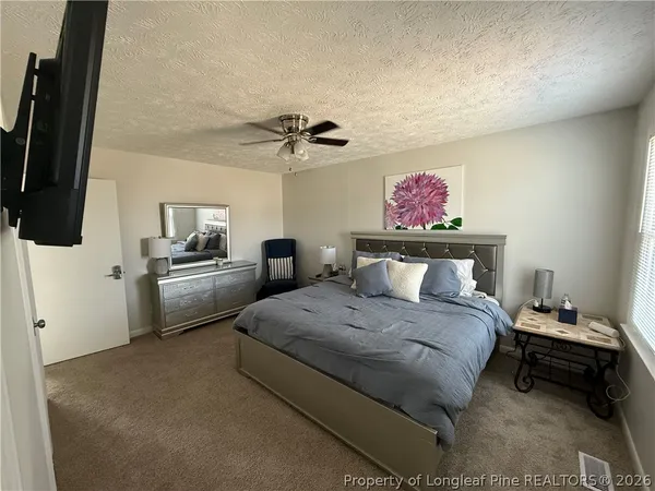 a bedroom with a bed furniture and a flat tv screen