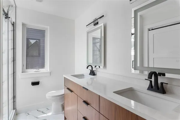 a bathroom with a sink a toilet and a mirror