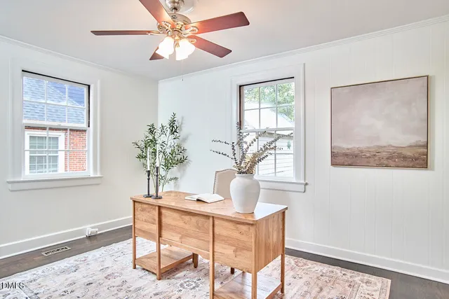 an empty room with wooden floor fan and windows