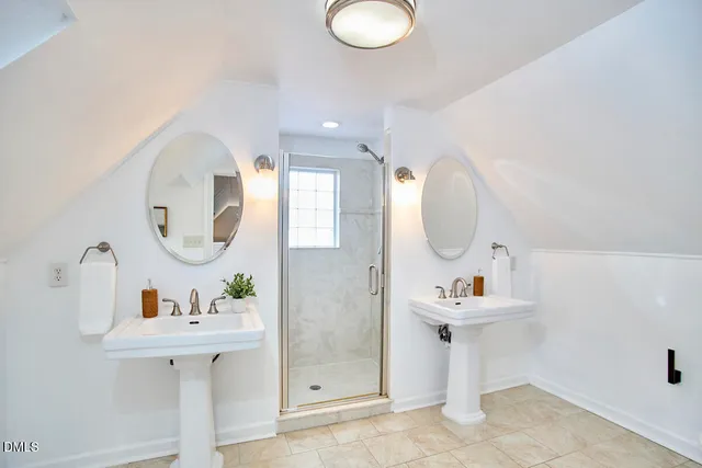 a bathroom with a granite countertop shower a sink and a window