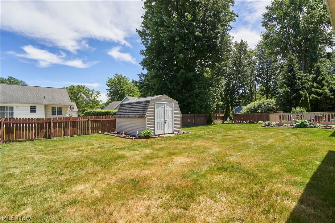 1963 Haines Road Madison, OH 44057 - Photo 33 of 34 Expansive backyard featuring a storage shed, wood fence enclosure, and mature trees