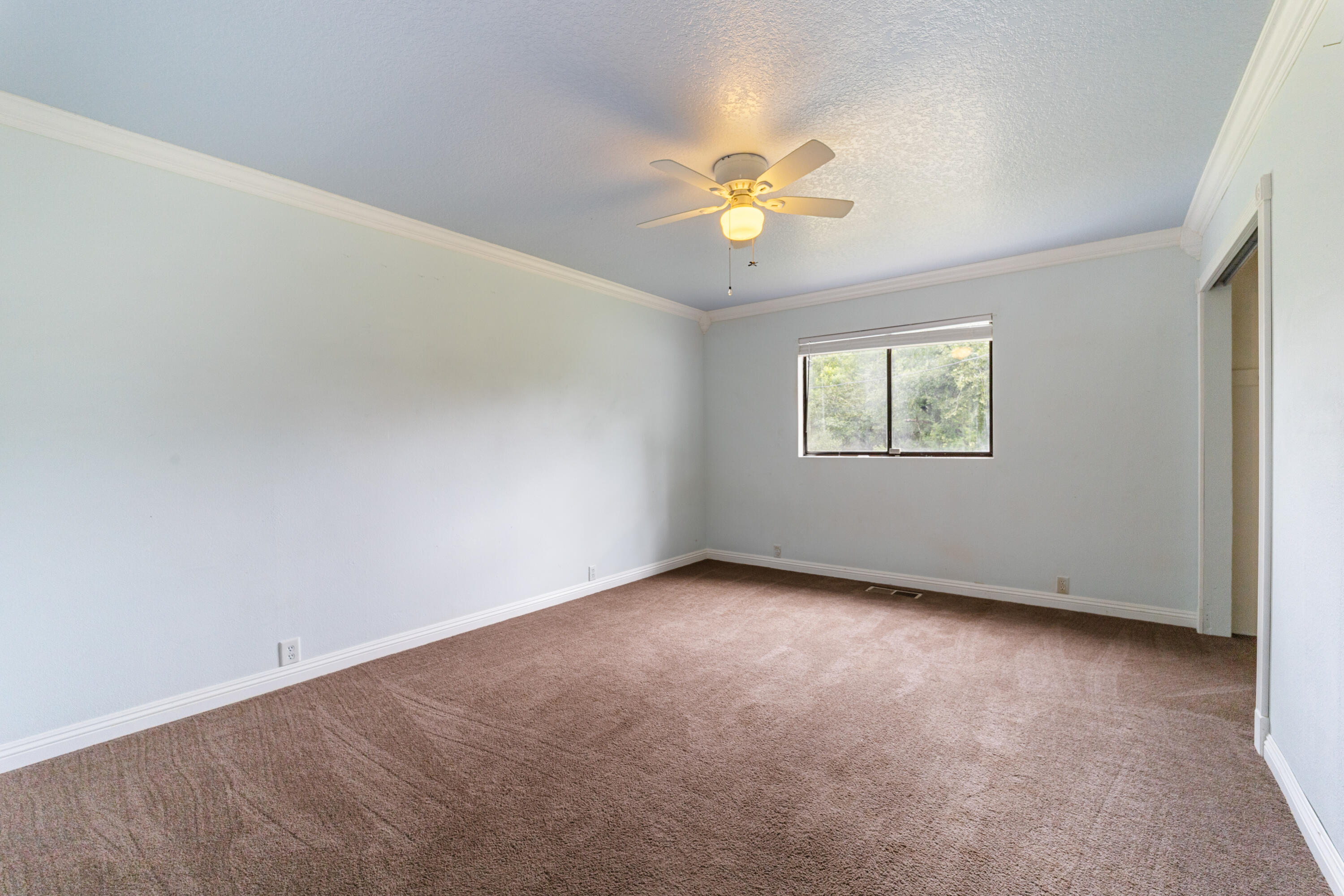 9891 Harley Leighton Road Redding, CA 96003 - Photo 41 of 52 an empty room with windows and chandelier fan