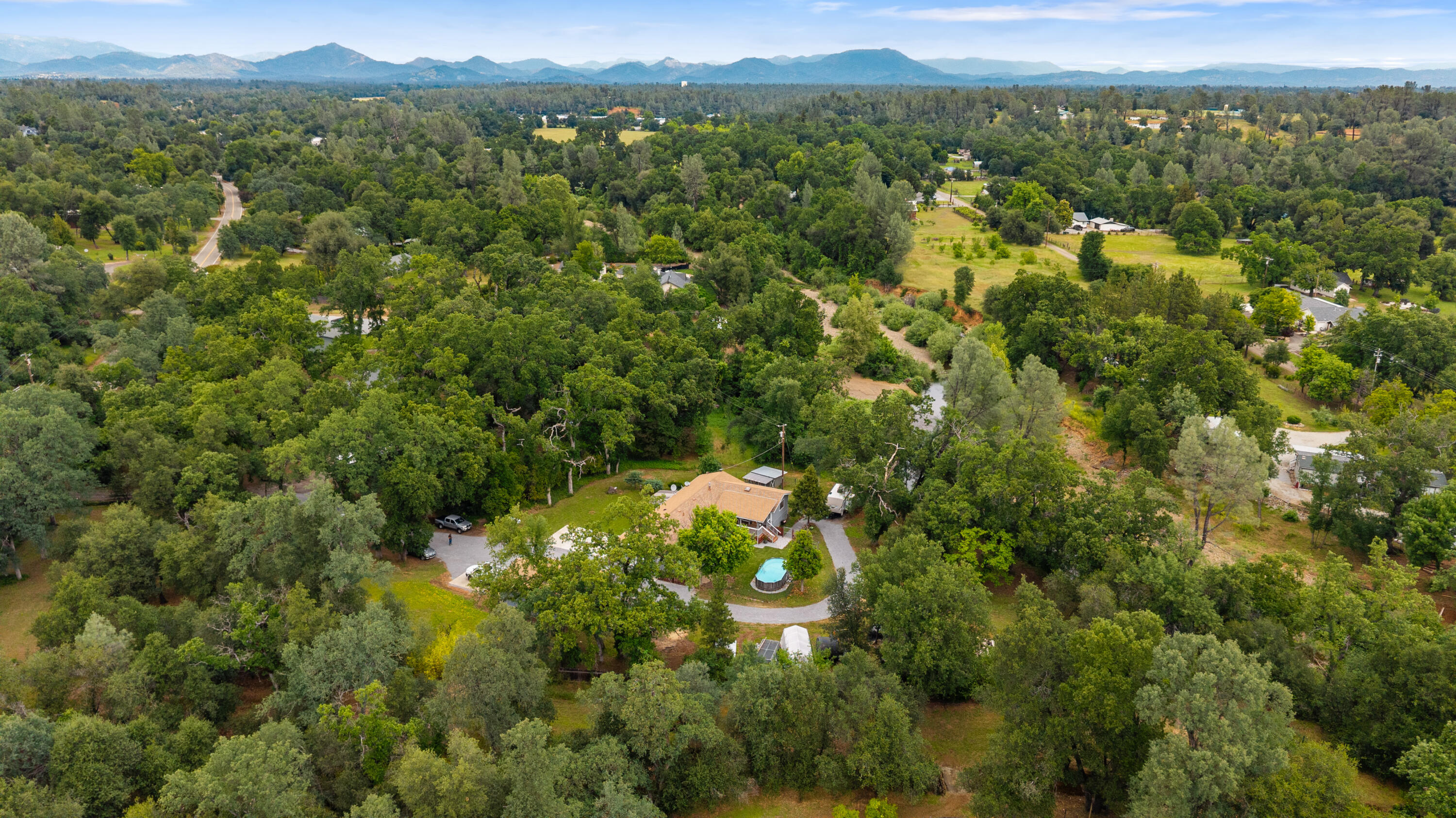 9891 Harley Leighton Road Redding, CA 96003 - Photo 51 of 52 an aerial view of a houses with a lush green hillside