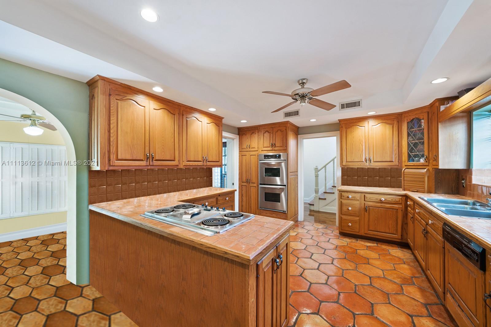 1333 Blue Road Coral Gables, FL 33146 - Photo 12 of 25 a kitchen with a sink refrigerator and cabinets