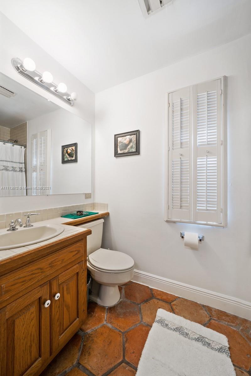 1333 Blue Road Coral Gables, FL 33146 - Photo 16 of 25 a spacious bathroom with a toilet sink and mirror