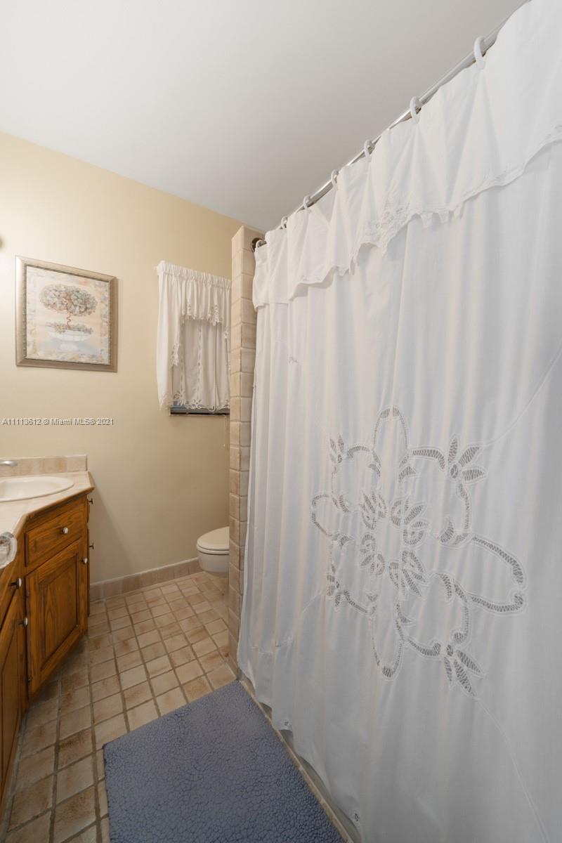 1333 Blue Road Coral Gables, FL 33146 - Photo 23 of 25 a bathroom with a shower curtain and a sink