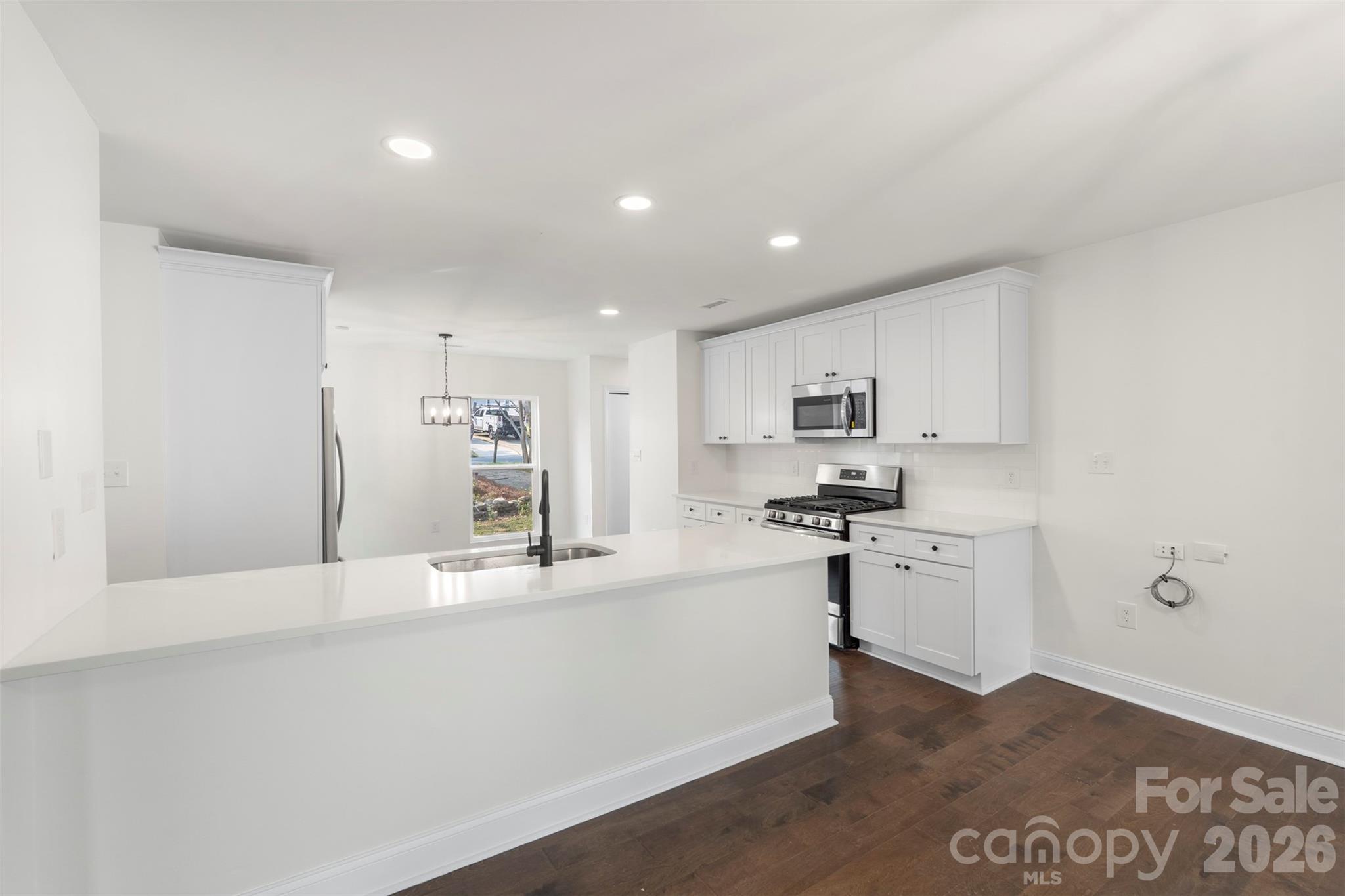 7308 Walterboro Road Charlotte, NC 28227 - Photo 16 of 43 a kitchen with stainless steel appliances kitchen island sink refrigerator and cabinets