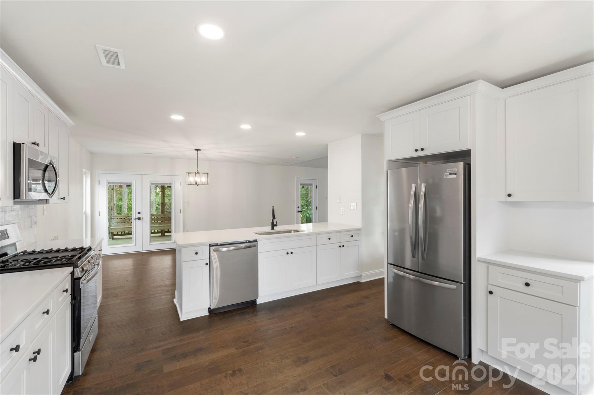 7308 Walterboro Road Charlotte, NC 28227 - Photo 17 of 43 a kitchen with white cabinets and stainless steel appliances