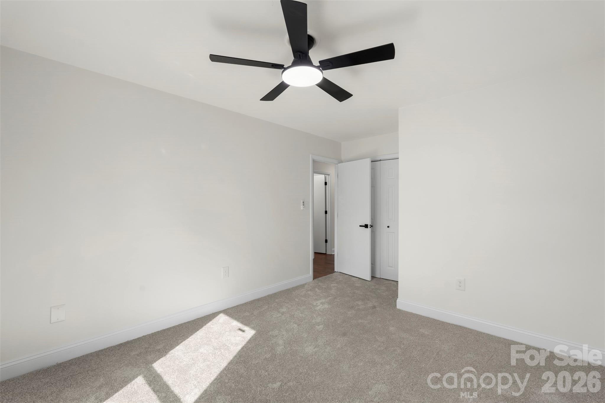 7308 Walterboro Road Charlotte, NC 28227 - Photo 28 of 43 an empty room with a ceiling fan and carpet