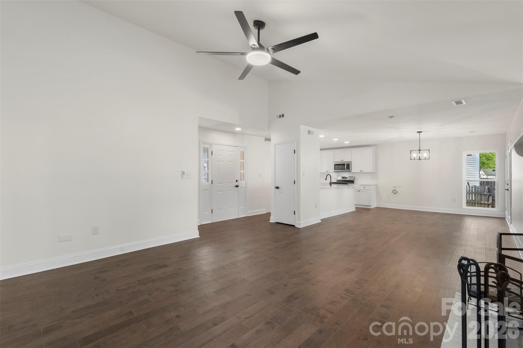 7308 Walterboro Road Charlotte, NC 28227 - Photo 10 of 43 a view of an empty room with a ceiling fan and kitchen view