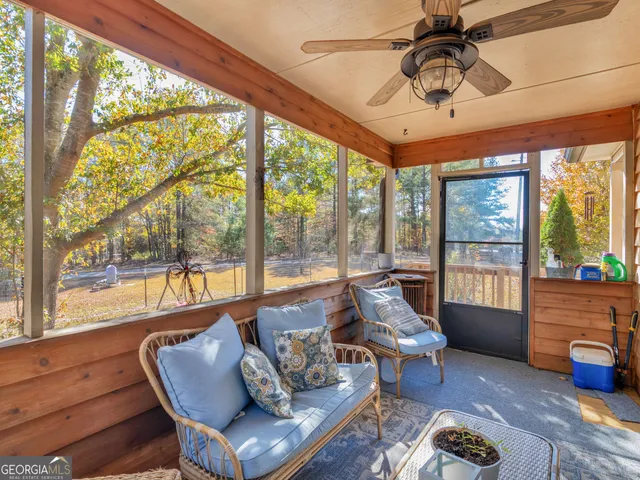 a living room with furniture and floor to ceiling windows