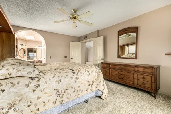 a spacious bedroom with a large bed and a dresser