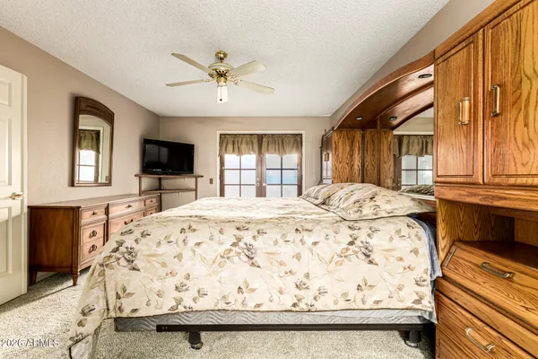 a spacious bedroom with a bed and a flat screen tv