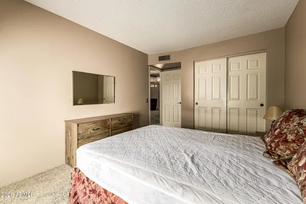 a spacious bedroom with a bed and a flat screen tv