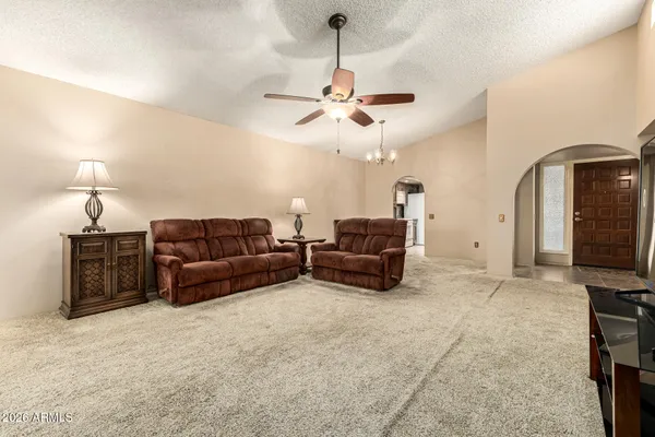 a living room with furniture a ceiling fan and a rug