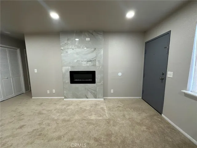 an empty room with kitchen chandelier and windows