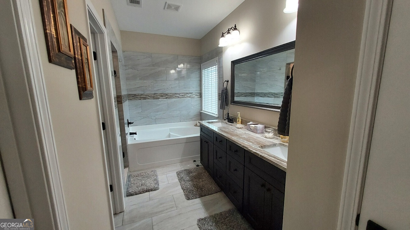 107 Lighterknot Trail Perry, GA 31069 - Photo 13 of 22 a bathroom with a double vanity sink and mirror