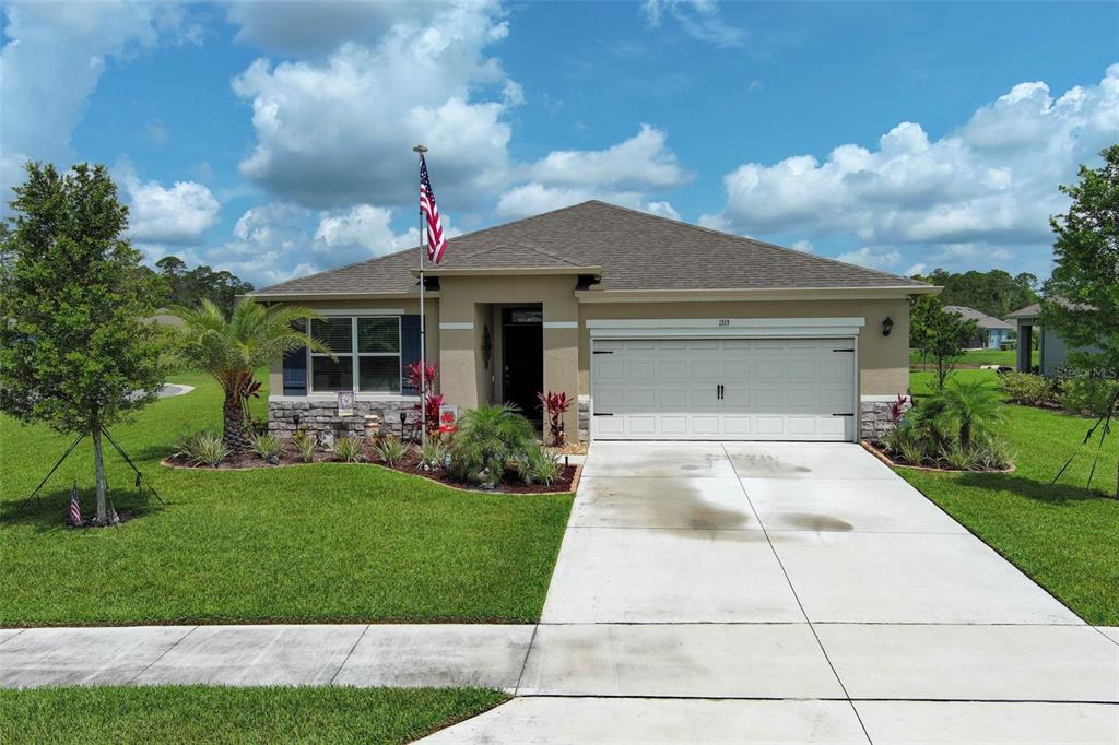 a front view of a house with a yard and trees
