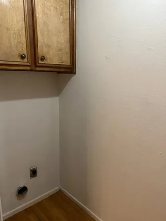 a view of a small space with wooden floor and a window