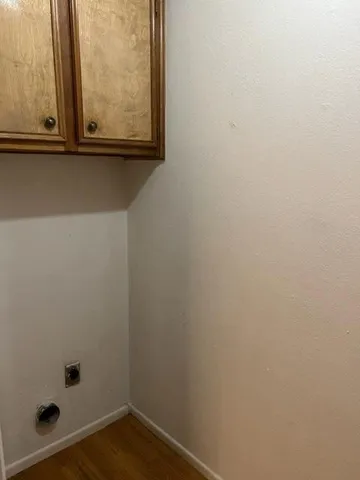 a view of a small space with wooden floor and a window