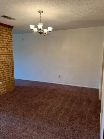 a view of a chandelier fan and fire place