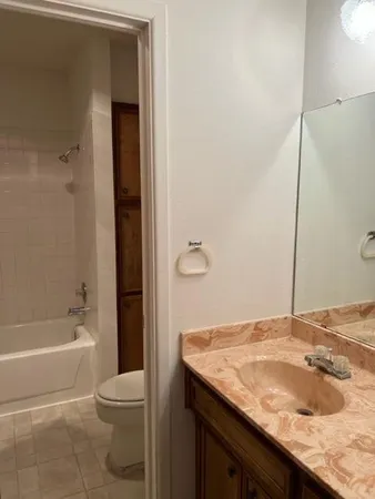 a bathroom with a granite countertop sink toilet and shower