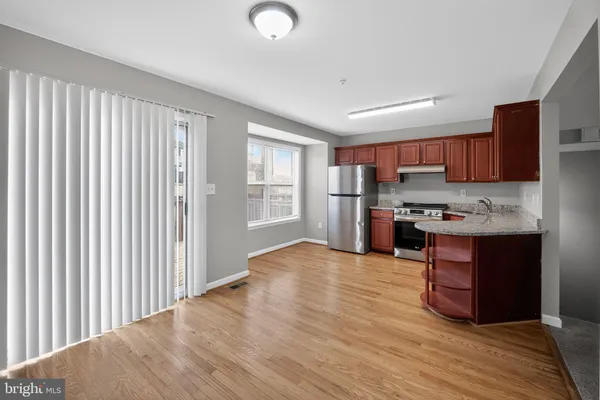 a kitchen with stainless steel appliances granite countertop a refrigerator and a stove top oven