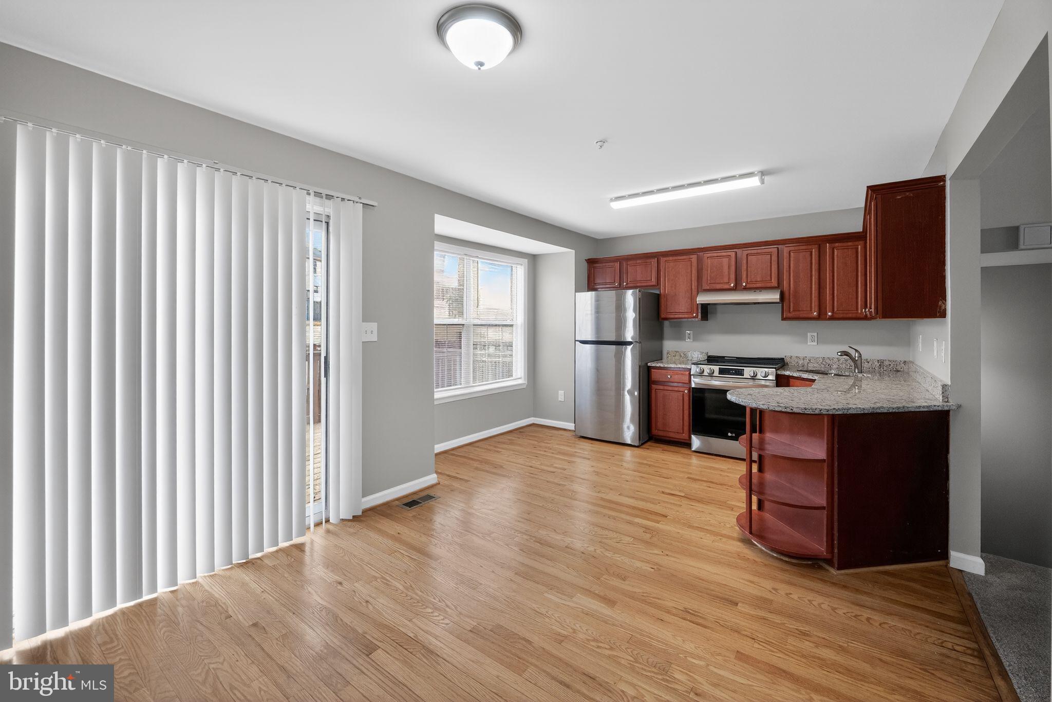 3524 Orchard Shade Road Randallstown, MD 21133 - Photo 12 of 34 a kitchen with stainless steel appliances granite countertop a refrigerator and a stove top oven