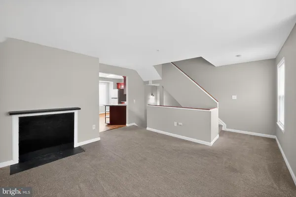 a view of an empty room with closet and a fireplace