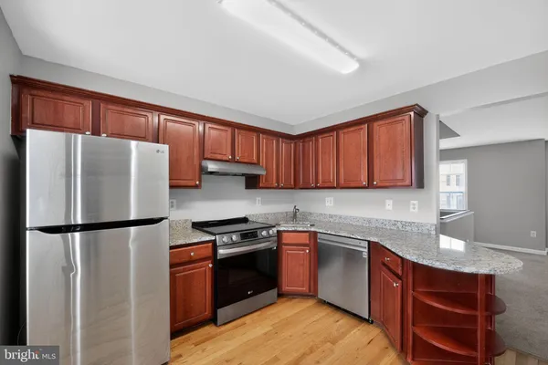 a kitchen with stainless steel appliances granite countertop a refrigerator stove a sink and dishwasher